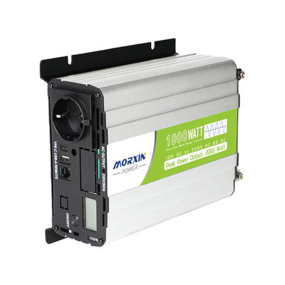 Silve Morxin Power 1000 watt pure sine wave power inverter with green label, displaying “Peak Power Output: 2000 Watt,” shown at an angle on a white background. The inverter features an AC outlet, USB ports, power switch, cooling vents, mounting brackets, and a small digital display.